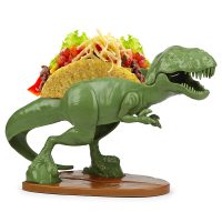 If you're pterotorial about your tacos our Tacosaurus Rex Taco Holder is just the lizard king for the job! Now the hunted becomes the hunter! Keep this fiercely loyal tyrannosaurus rex fed with yummy noms, and he'll be raptor round your finger! And while he's best know for defending your tacos, he also enjoys a good BLT - bacon, lettuce, tyrannosaurus rex! THE ULTIMATE TACO HOLDER: Tacosaurus Rex Taco Holder. Holds 2 Tacos! NOT JUST FOR TACOS: Try it with Waffles, Toast, Sandwiches, Ice Cream Tacos, Crackers and more! FUN FOR ALL AGES: Perfect for kids and adults that are looking to add a bit of fun to the dinner table! FOOD-SAFE: BPA free, lead free and phthalate free. EASY TO CLEAN: Top rack dishwasher safe. Not microwaveable. Watch with delight as our Tacosaurus Rex turns your little monsters into content and docile critters. This prehistoric titan carries two tacos and makes every meal a thrilling adventure! This 100-percent food-safe polypropylene taco holder can handle just about anything young children do to them. It's the ultimate gift for dinosaur lovers! BPA free, lead free and phthalate free to meet or exceed current safety standards. Dimensions: 9.5 inches tall x 4.5 inches wide x 6 inches long. Our Tacosaurus Rex Taco Holder is dinomite!